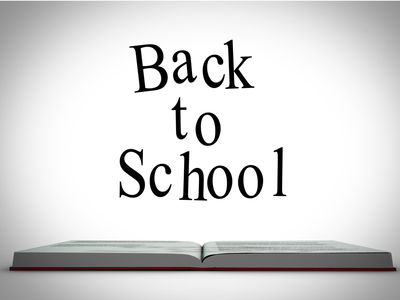 Back to school message above open book graphic on white background with vignette